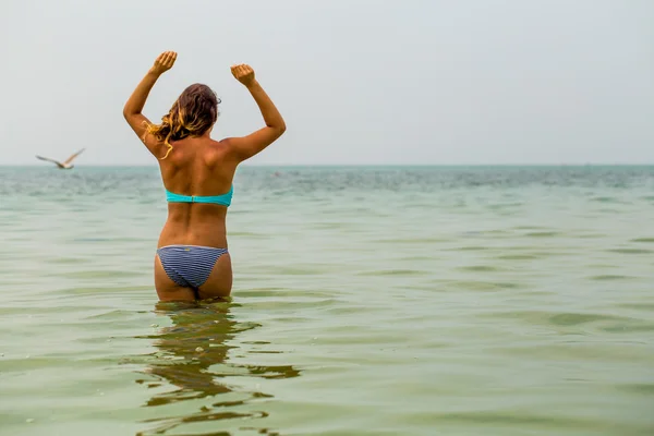 Beautiful girl, standing alone in the sea