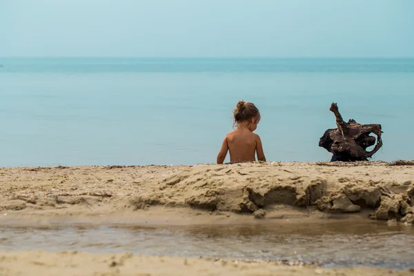 Niña desnuda juega en el mar, hermosa playa — Foto de Stock