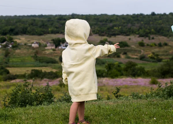 Прелестная маленькая девочка в облачную погоду в маминой одежде. — стоковое фото
