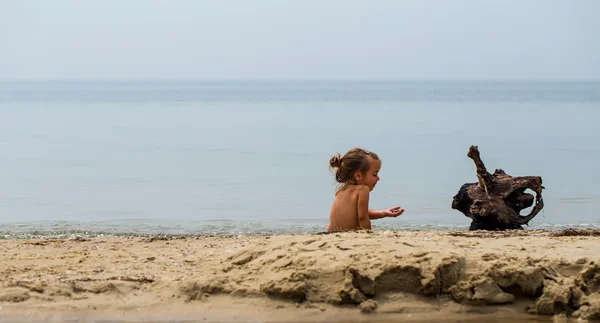 Niña desnuda juega en el mar, hermosa playa — Foto de Stock