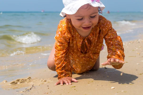 Söt liten tjej kryper på stranden, glada barn, känslor — Stockfoto