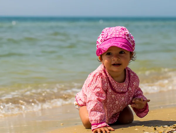 Söt liten tjej kryper på stranden, glada barn, känslor — Stockfoto