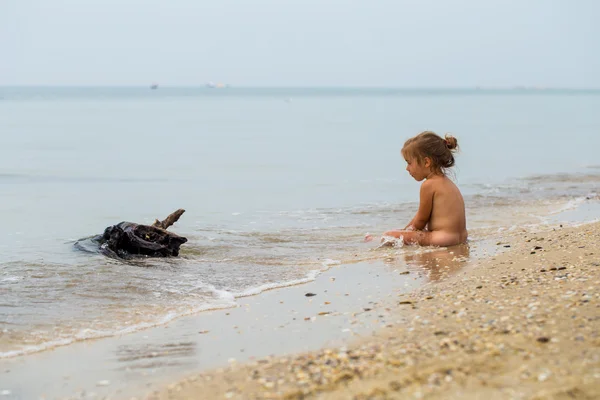 Niña desnuda juega en el mar, hermosa playa — Foto de Stock
