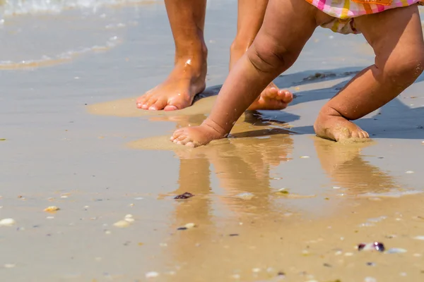 Niños y adultos pies en la playa, una madre con niño, familia — Foto de Stock