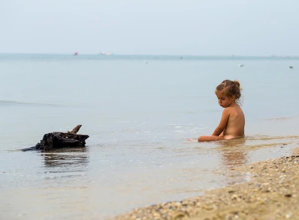 Niña desnuda juega en el mar, hermosa playa — Foto de Stock