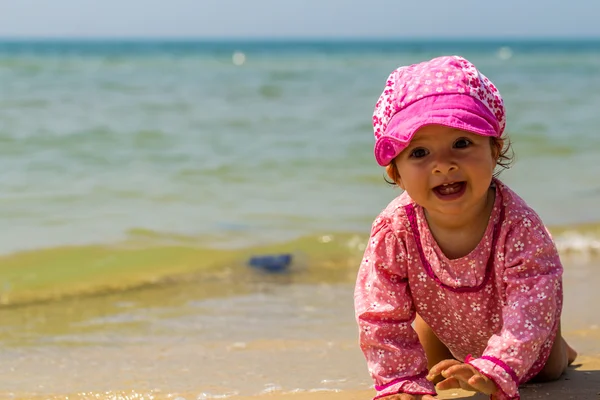 Bonita niña arrastrándose en la playa, el niño alegre, emociones — Foto de Stock