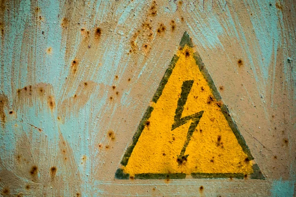 sign electrical hazard placed on rusty metal panel.