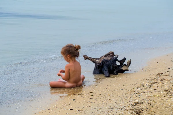 Naken liten flicka leker i havet, vackra stranden — Stockfoto