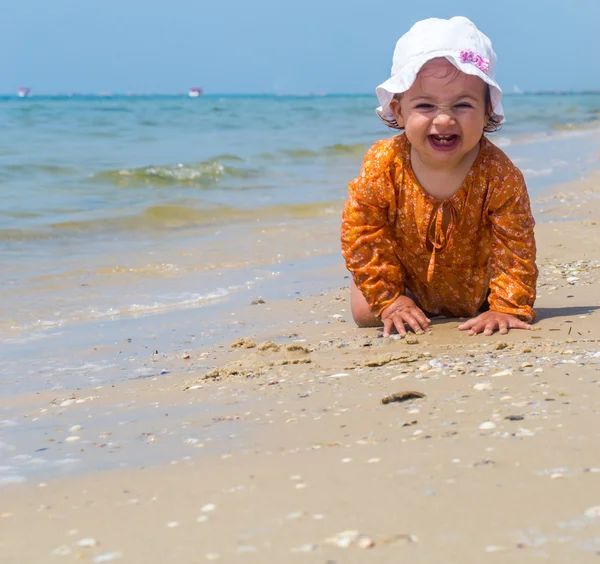 Bonita niña arrastrándose en la playa, el niño alegre, emociones — Foto de Stock