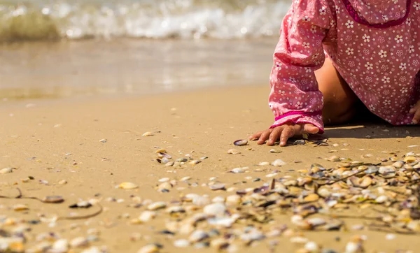 Bonita niña arrastrándose en la playa, el niño alegre, emociones — Foto de Stock