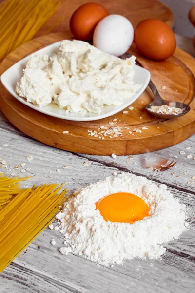 Cozinhar espaguete em um fundo de madeira ovos de leite — Fotografia de Stock