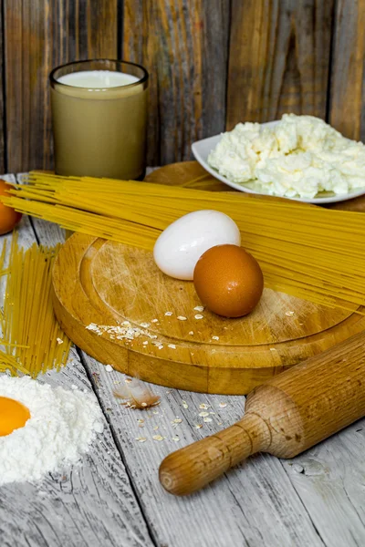 Cozinhar espaguete em um fundo de madeira ovos de leite — Fotografia de Stock