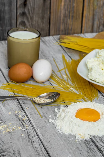 Cozinhar espaguete em um fundo de madeira ovos de leite — Fotografia de Stock