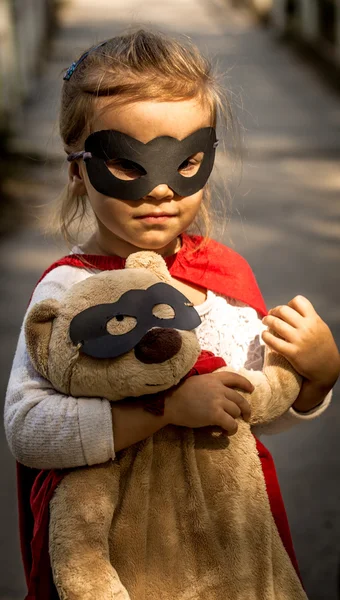 Красивая маленькая девочка в образе супергероя, играющего — стоковое фото