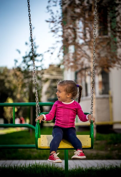 Linda menina brincando no parque infantil — Fotografia de Stock