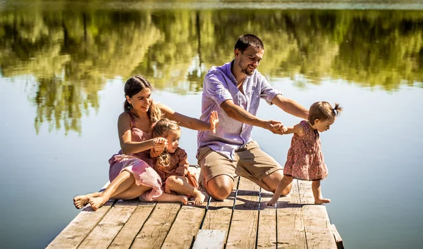 Jovem família no cais perto do lago — Fotografia de Stock