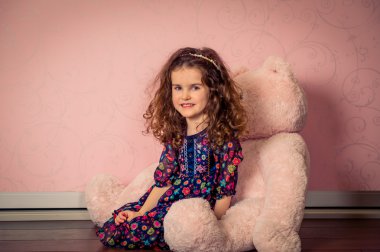 küçük kız bir bebek pembe odada büyük yumuşak ayı çalış