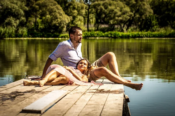 Hermosa pareja joven en el muelle cerca del río —  Fotos de Stock
