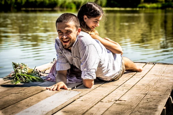 Hermosa pareja joven en el muelle cerca del río —  Fotos de Stock