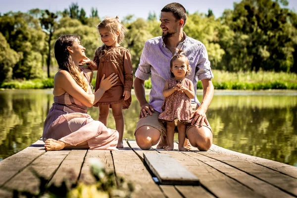 Familia joven en el muelle cerca del lago — Foto de Stock
