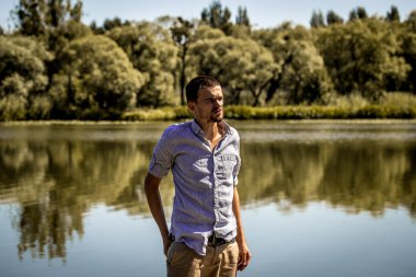 Rıhtımda gömlek ve şort giyen genç adam