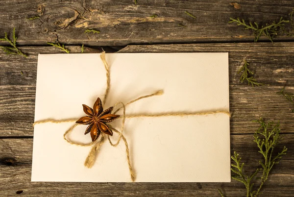 松ぼっくりとクリスマス プレゼント木製の背景に白い封筒 — ストック写真