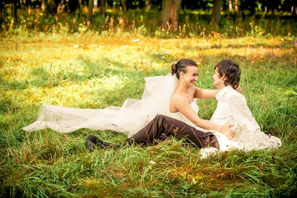 Lyckliga bruden och brudgummen på en promenad i vacker skog — Stockfoto
