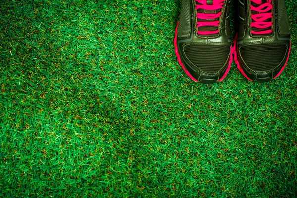 Sportovní boty na pozadí zelené trávy — Stock fotografie