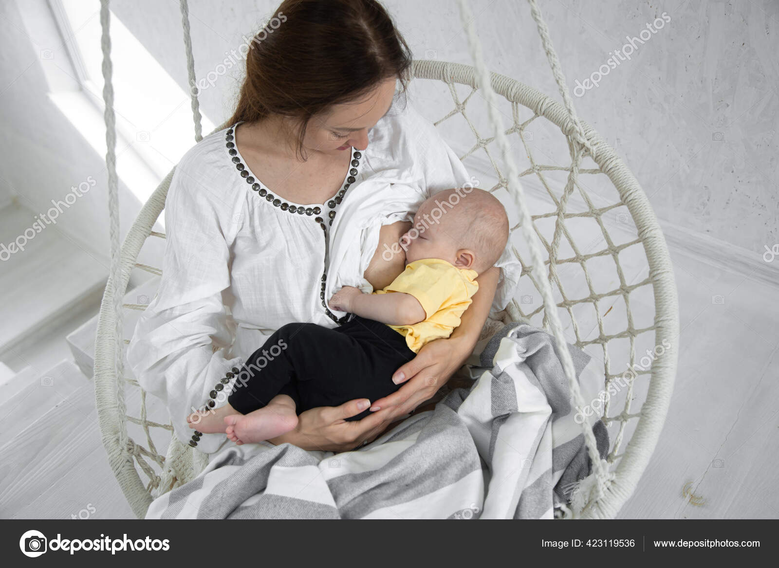 妈妈在浅色背景的白色吊床椅子上给新生婴儿喂奶母乳育婴概念头条新闻 图库照片 C Puhimec