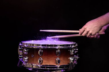 Trampet çalan davulcu siyah arkaplanda davul çalıyor. Yakın plan..