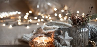 Dekoratif bir şamdanla yanan mumlarla samimi bir Noel kompozisyonu. Ev konforu ve sıcaklık kavramı.