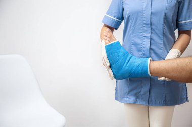 Hastanede bandajlandıktan sonra bir adamın bacağını alçıyla ve mavi bir bantla kapat..