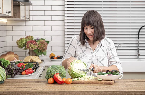 Schöne Brünette Lächelt Und Schneidet Kohl Für Salat Vor Dem — Stockfoto