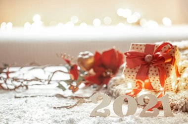 Ahşap yeni yıl numaraları ve bulanık arkaplanda dekorasyon detaylarıyla Noel kompozisyonu.