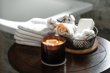 Mumlar, banyo havluları, sabun ve pamuktan oluşan sıcacık bir spa kompozisyonu. Vücut bakımı ve hijyen kavramı.