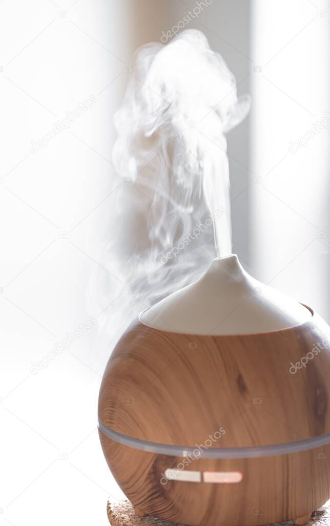 Aroma oil diffuser lamp on a table. Aromatherapy and health care concept.