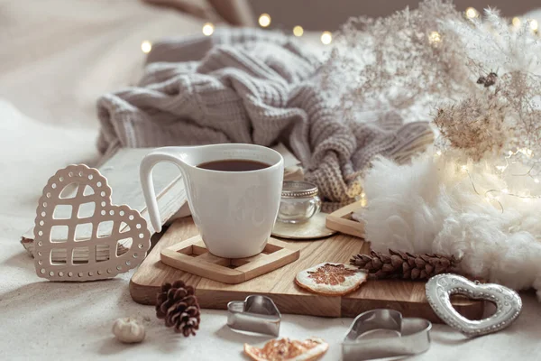 A cup of hot drink and cute home decor items. The concept of home comfort and aesthetics.