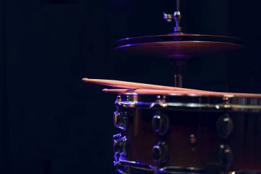 Karanlıktaki güzel ışıklandırmalı davul setinin bir parçası. Konser ve performans konsepti.