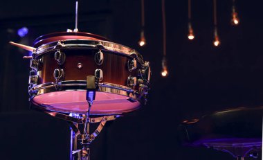 Karanlıktaki güzel ışıklandırmalı davul setinin bir parçası. Konser ve performans konsepti.