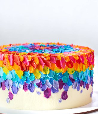 Parlak kremayla süslenmiş çok renkli doğum günü pastası. Özel kek konsepti.