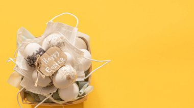 Tıbbi tek kullanımlık koruyucu maskeler ve dekoratif yumurtalar. Koronavirüs salgını sırasında alışılmadık Paskalya.