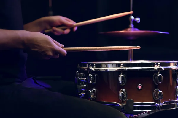 ドラムを演奏するドラマーは暗闇のスネアドラムに固執する コンサートとライブパフォーマンスのコンセプト — ストック写真