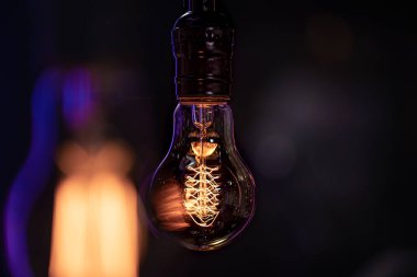 Karanlıkta yanan bir lamba bulanık bir arka planda asılı duruyor. Dekor ve atmosfer kavramı.