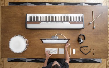 Müzik aletlerinin bir kayıt stüdyosundaki ahşap bir masanın üzerindeki kompozisyonunun en üst görüntüsü. Müzisyenlerin yaratıcılık için iş yeri.