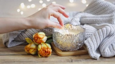 Sevgililer Günü için rahat bir ev kompozisyonu, bir mum, bir örgü ögesi, çiçekler ve yazıtlar aşk....