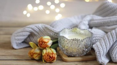 Sevgililer Günü için rahat bir ev kompozisyonu, bir mum, bir örgü ögesi, çiçekler ve yazıtlar aşk....