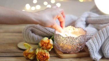 Sevgililer Günü için rahat bir ev kompozisyonu, bir mum, bir örgü ögesi, çiçekler ve yazıtlar aşk....