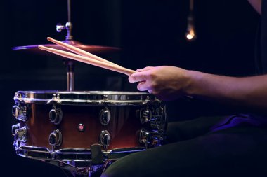 Davulcu karanlıkta trampet çalarken. Konser ve canlı performans konsepti.