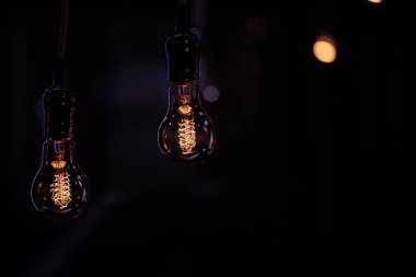 Boke 'tan karanlıkta iki parlak lamba sarkıyor. Dekor ve atmosfer kavramı.