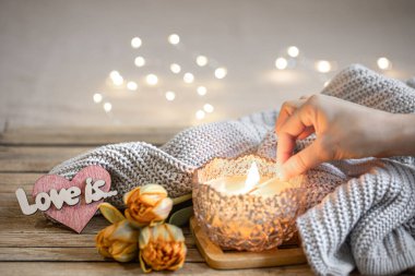 Evde romantik mum, dekor, taze çiçekler ve Bokeh ile bulanık arka planda örülmüş elementlerle dolu bir hayat..